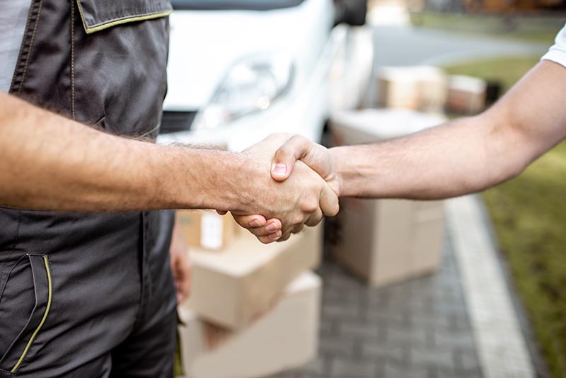 Delivery men shaking hands, close-up