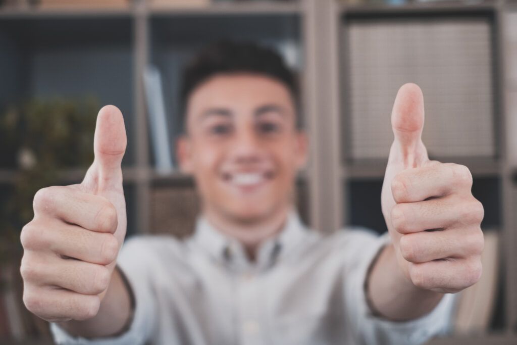 Close-up focus on the male hand with a thumbs-up gesture