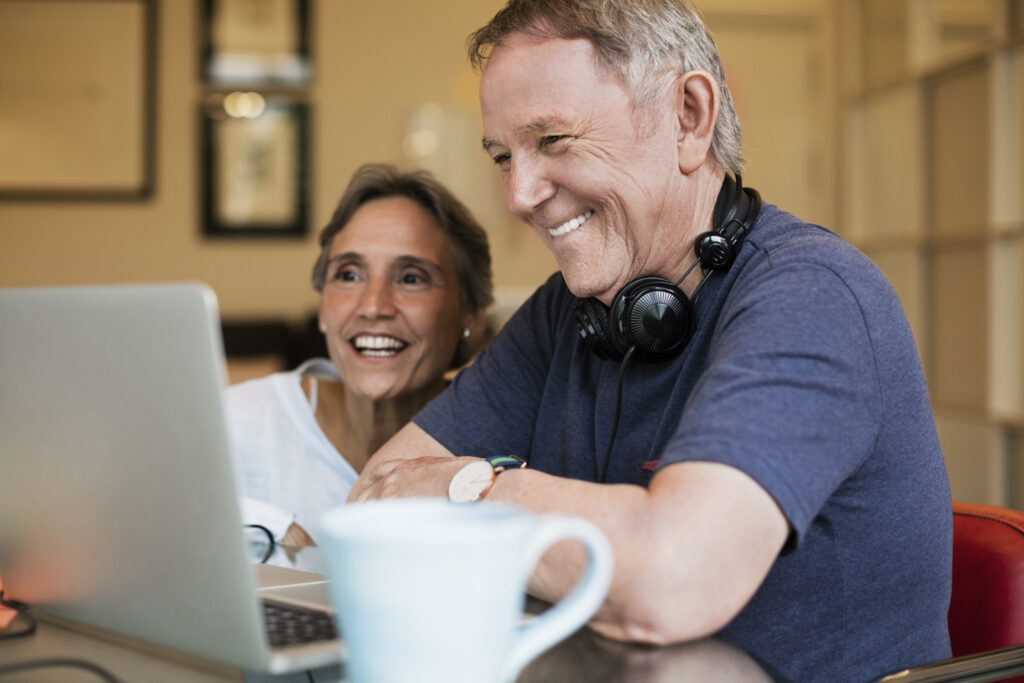 Happy Senior Couple Using Laptop At Home